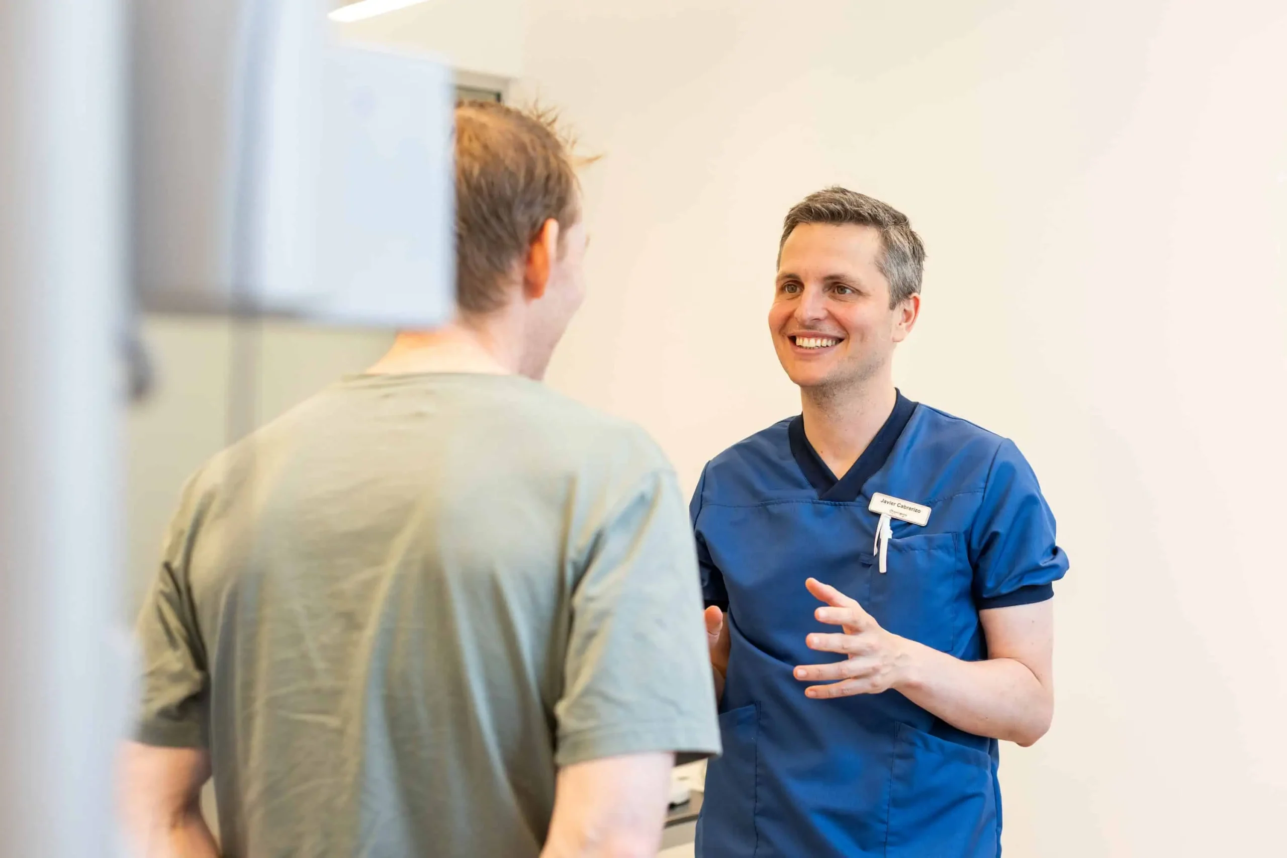 øjenlæge snakker smilende med en patient