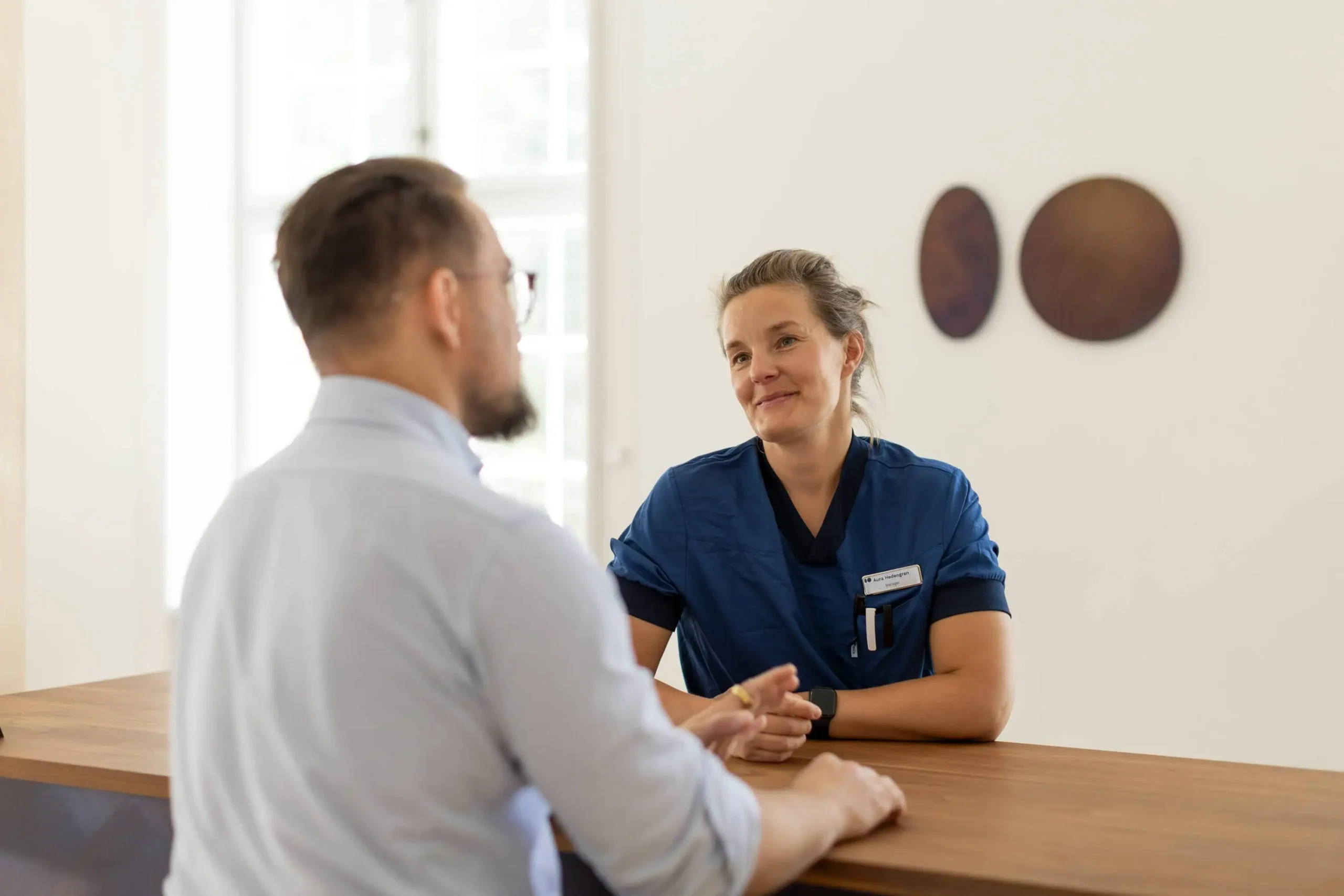 øjenlæge sekretær snakker med patient