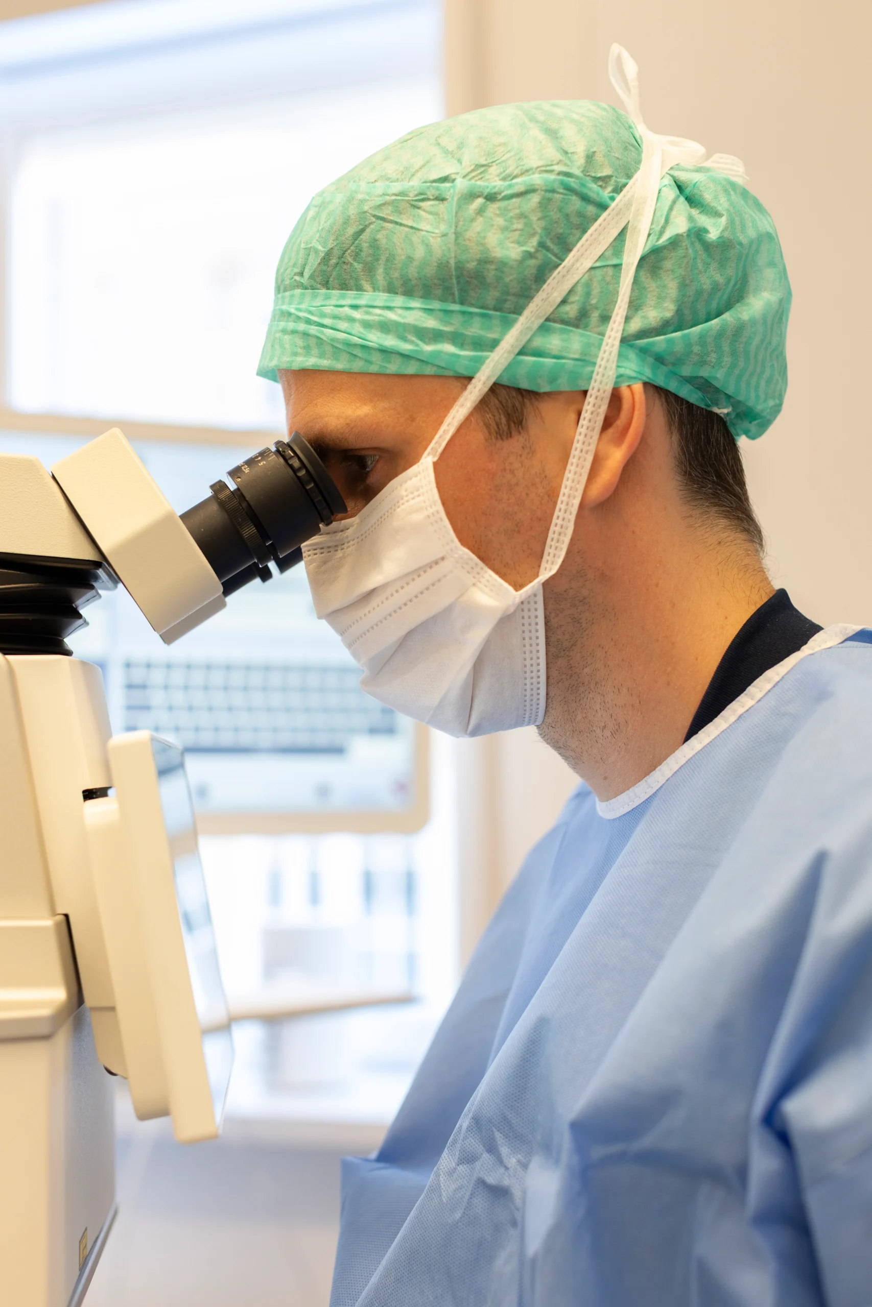 øjenlæge kigger i mikroskop