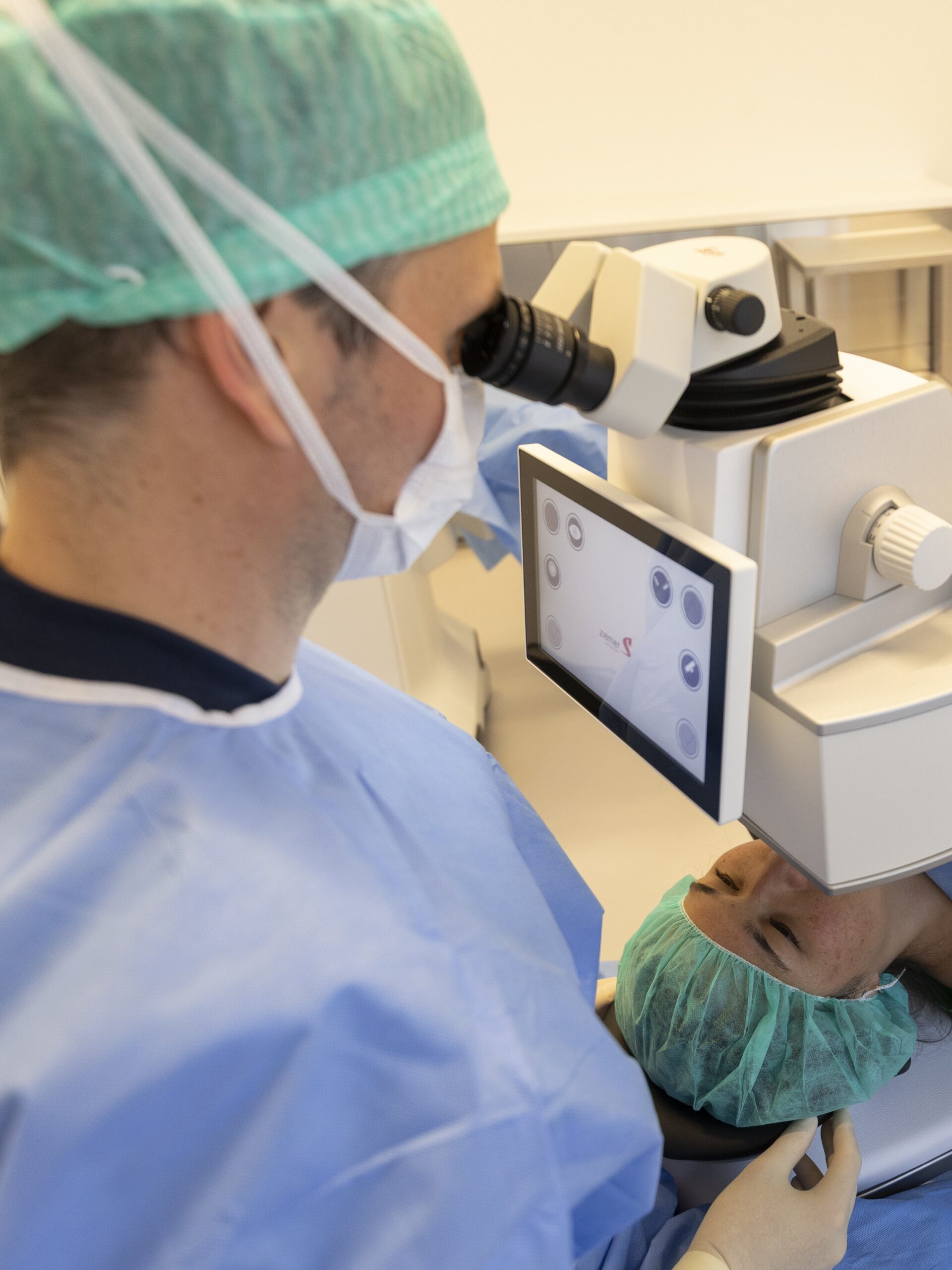 Øjenlæge kigger i øjenlaser med en patient