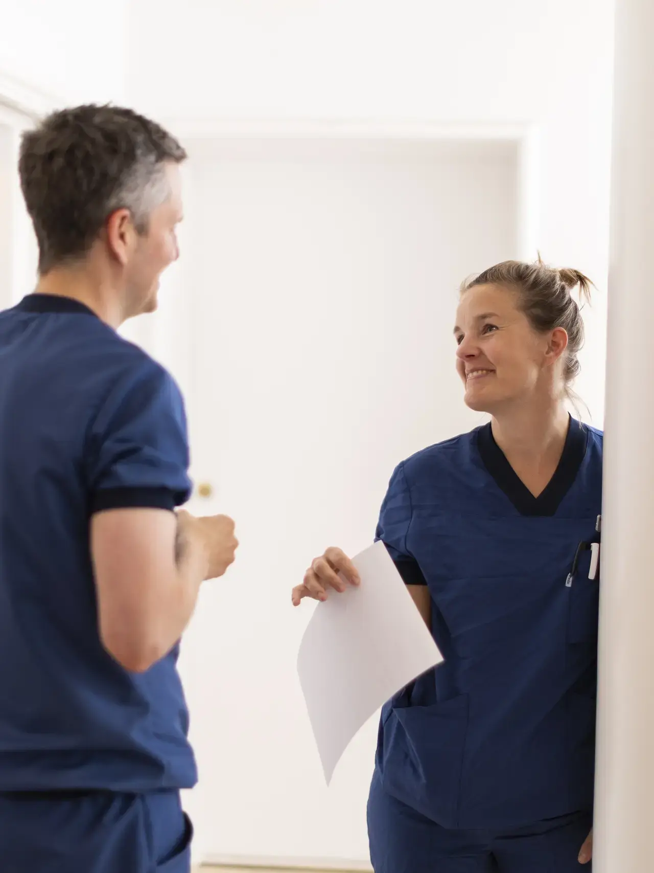 Lægesekretær og øjenlæge snakker sammen i en øjenklinik